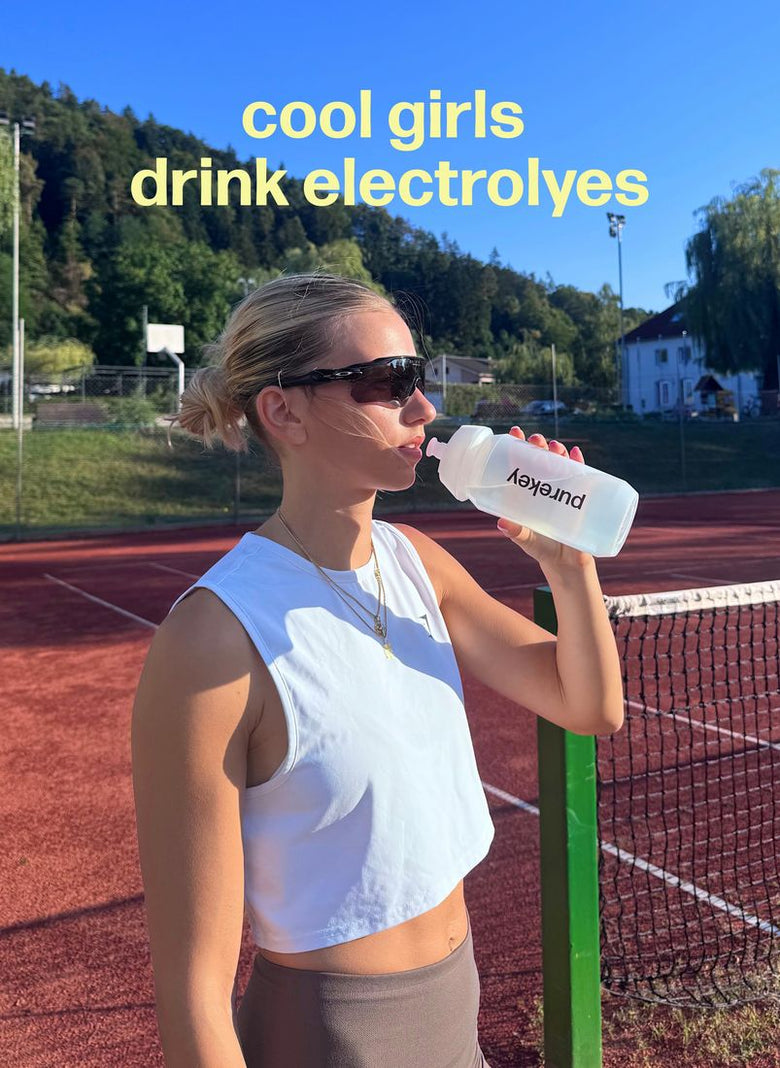 Drinking from a Purekey bottle on a tennis court