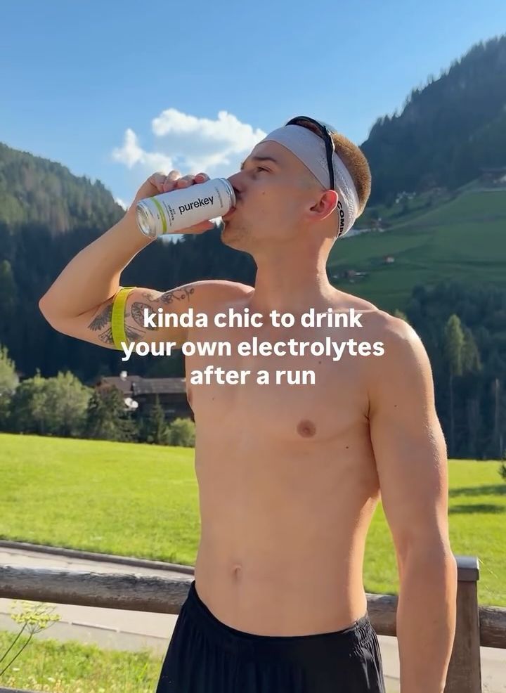 Runner drinking from a Purekey can in the mountains